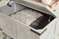 Carynhurst Cocktail Table with Storage Furniture Mart -  online today or in-store at our location in Duluth, Ga. Furniture Mart Georgia. View our lowest price today. Shop Now. 